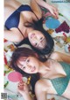 A couple of women laying on top of a bed.