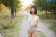 A woman in a white bodysuit holding a bowl of food.