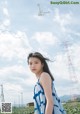 A woman in a blue and white dress standing in a field.