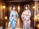 A couple of women in kimonos standing next to each other.