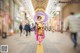 A woman in a kimono walking down a street holding an umbrella.