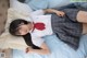 A woman in a school uniform laying on a bed.