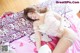 A woman laying on top of a bed with a hello kitty pillow.