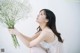 A woman holding a bunch of white flowers in her hand.